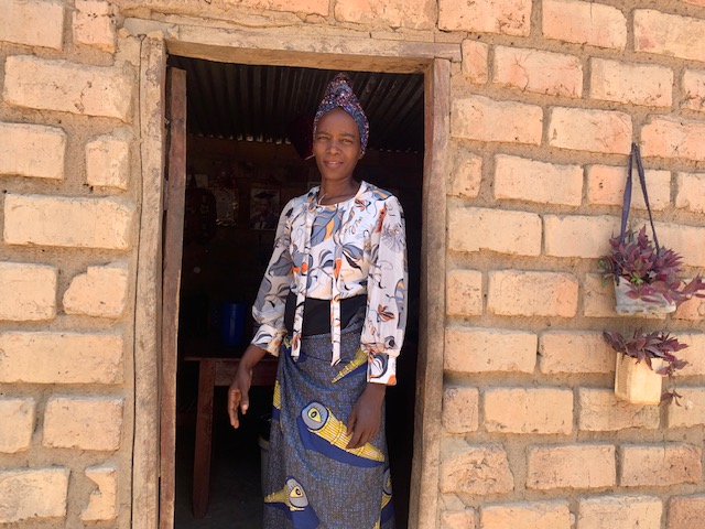 Naomi greeting us outside her tidy small home