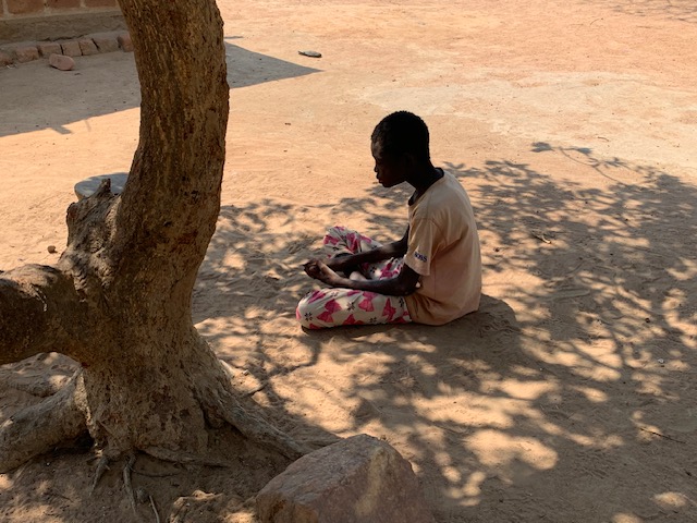 Eldest Dimuna boy sits under a tree