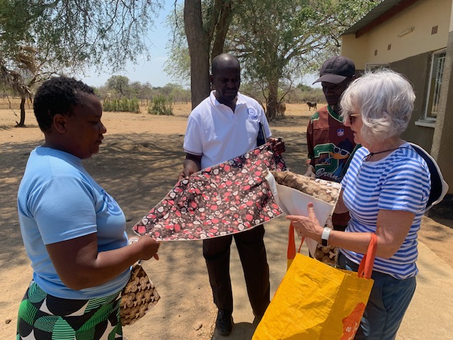 Liz giving the House mother waterproof and washable mattress__ protectors.
