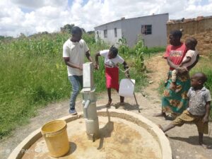 Disabled mother, Priscilla, accessing water from the new bore hole.__